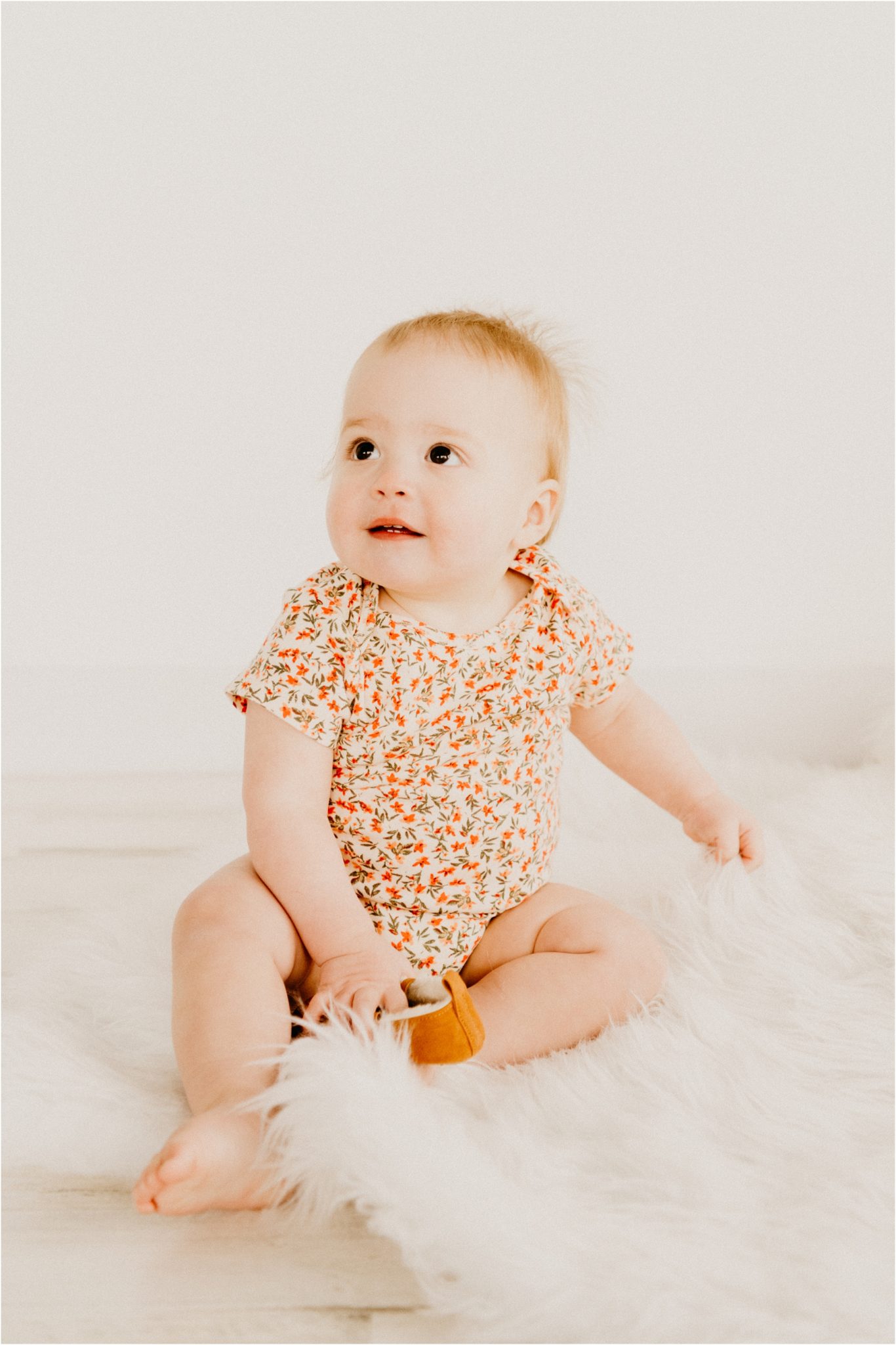 studio photography baby smiling at camera with white pillow