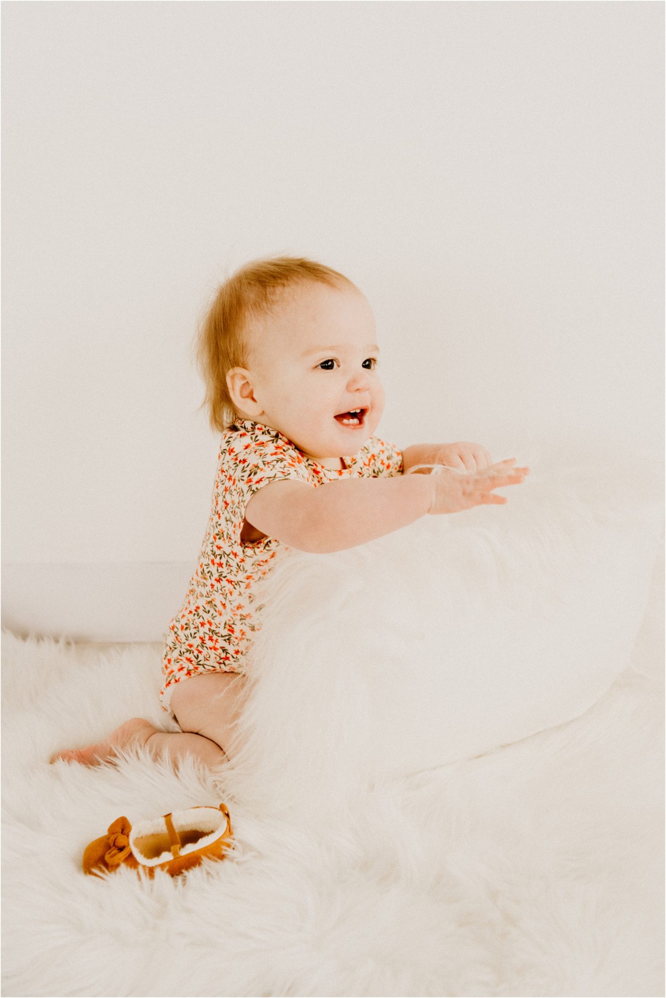 baby smiling at camera with white pillow