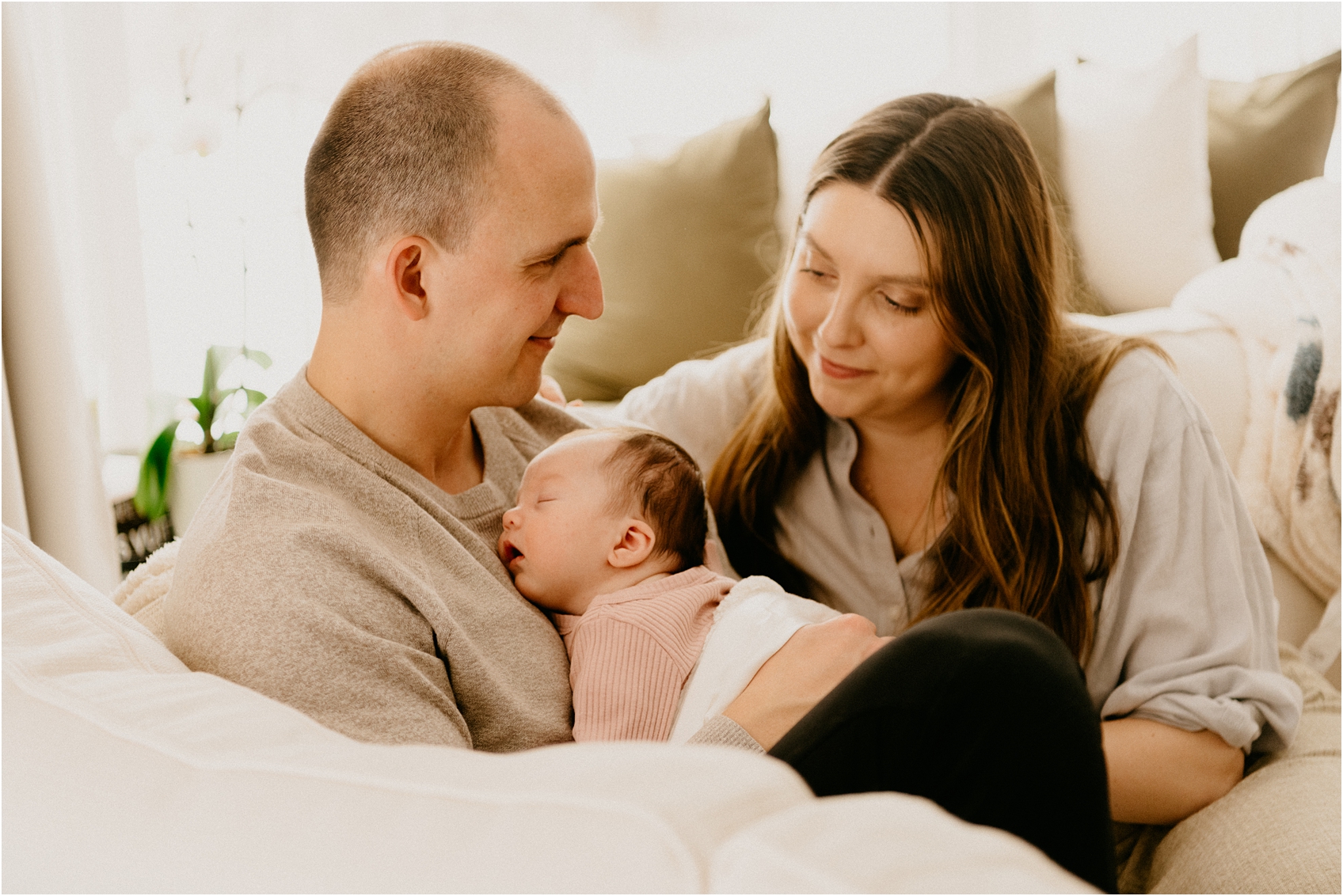 mom and dad and baby on a couch