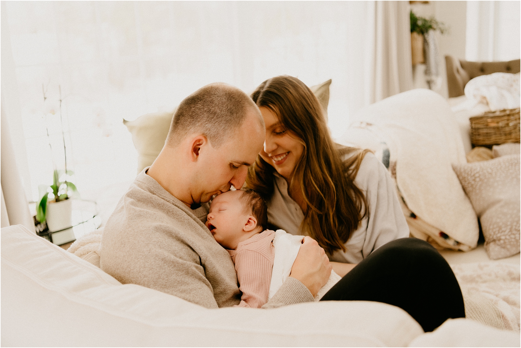 mom and dad and baby on a couch