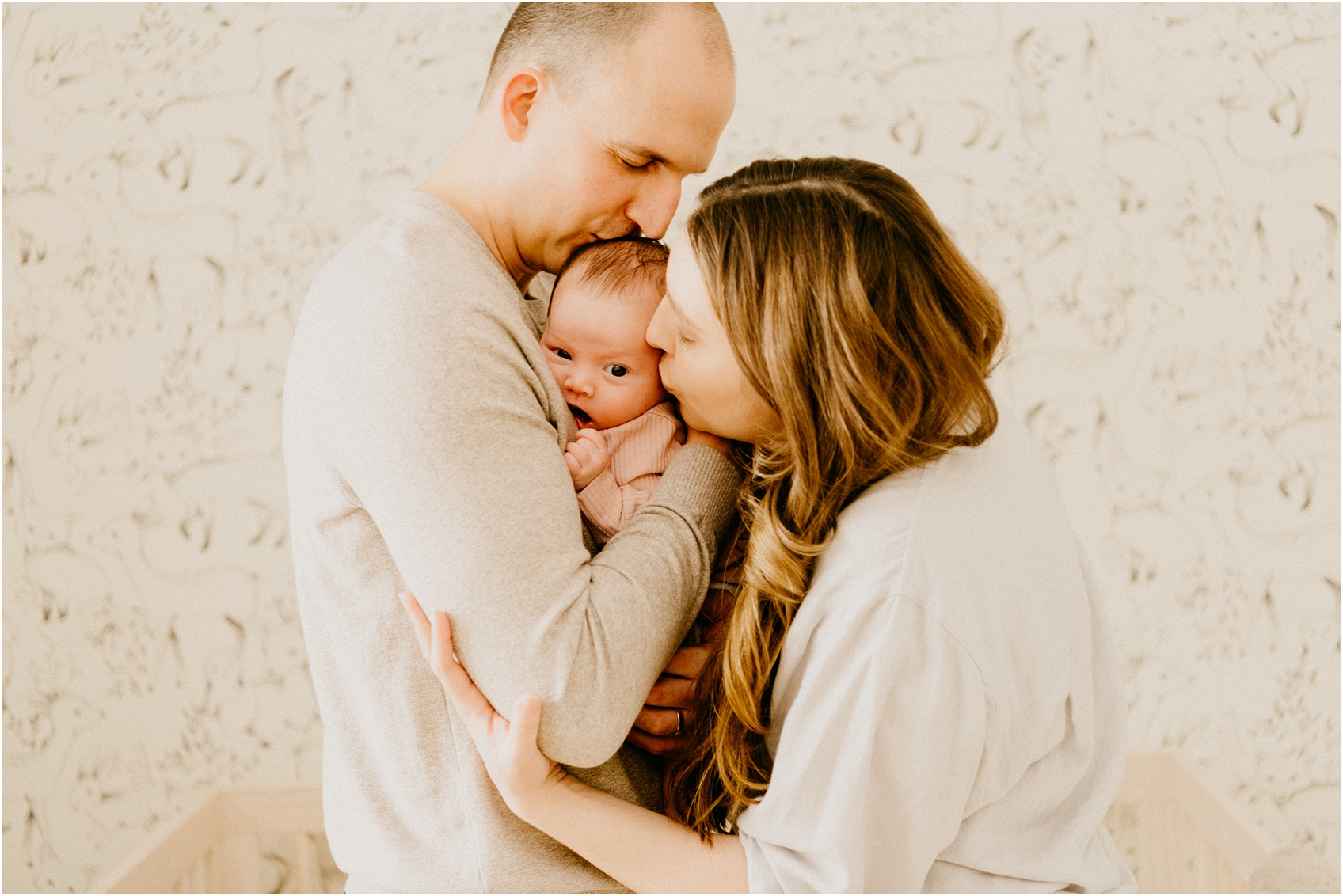 mom and dad kissing baby