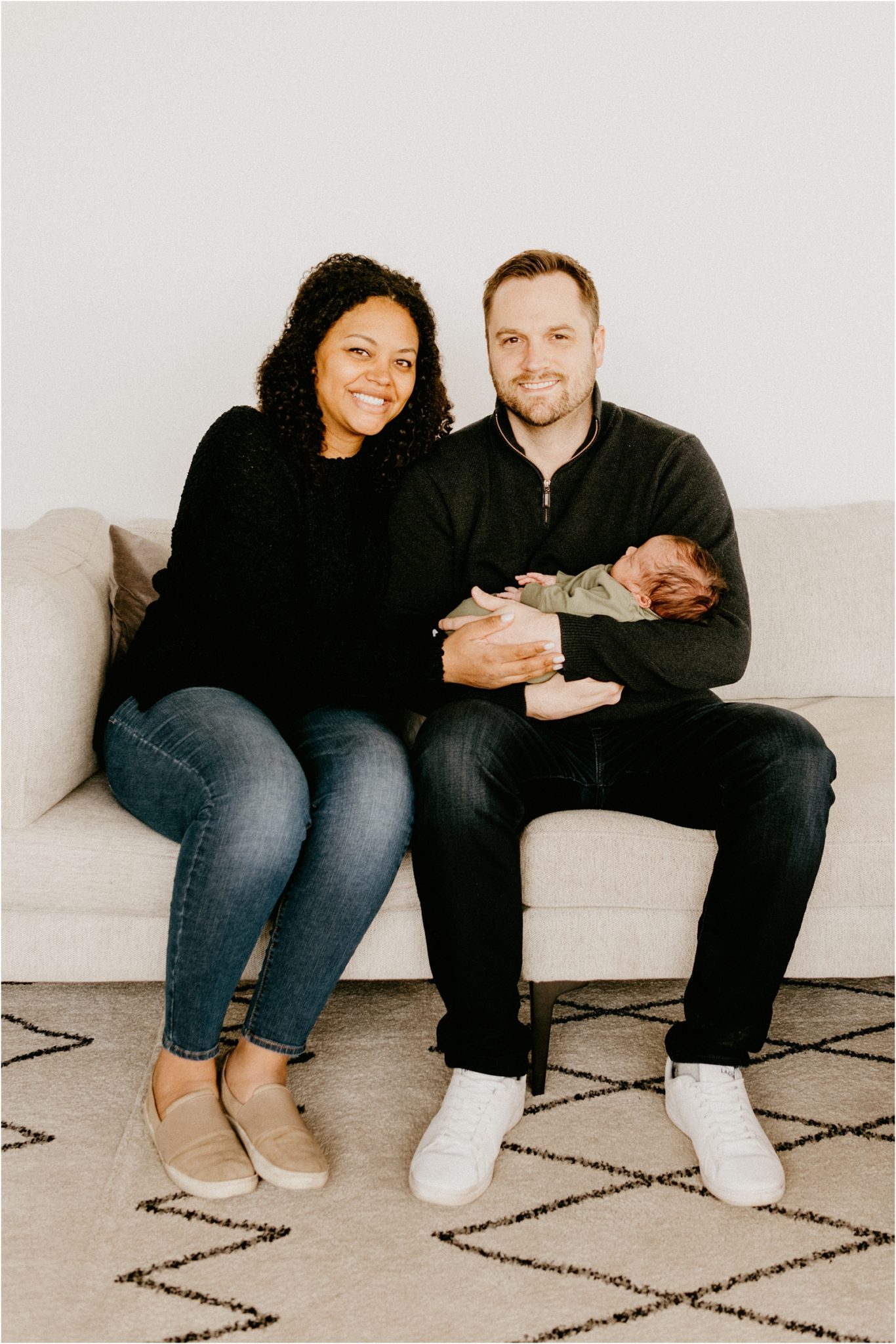 family sitting on couch with baby