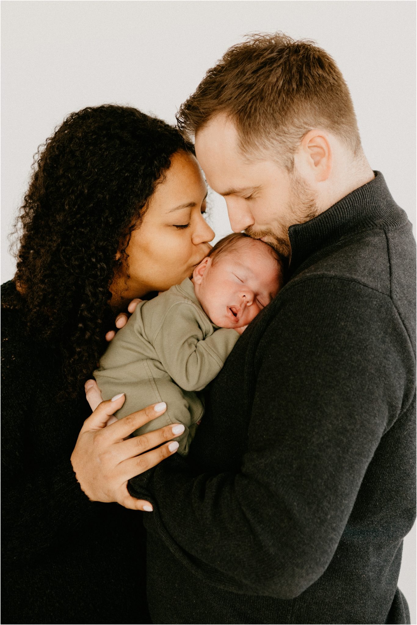 parents kissing baby