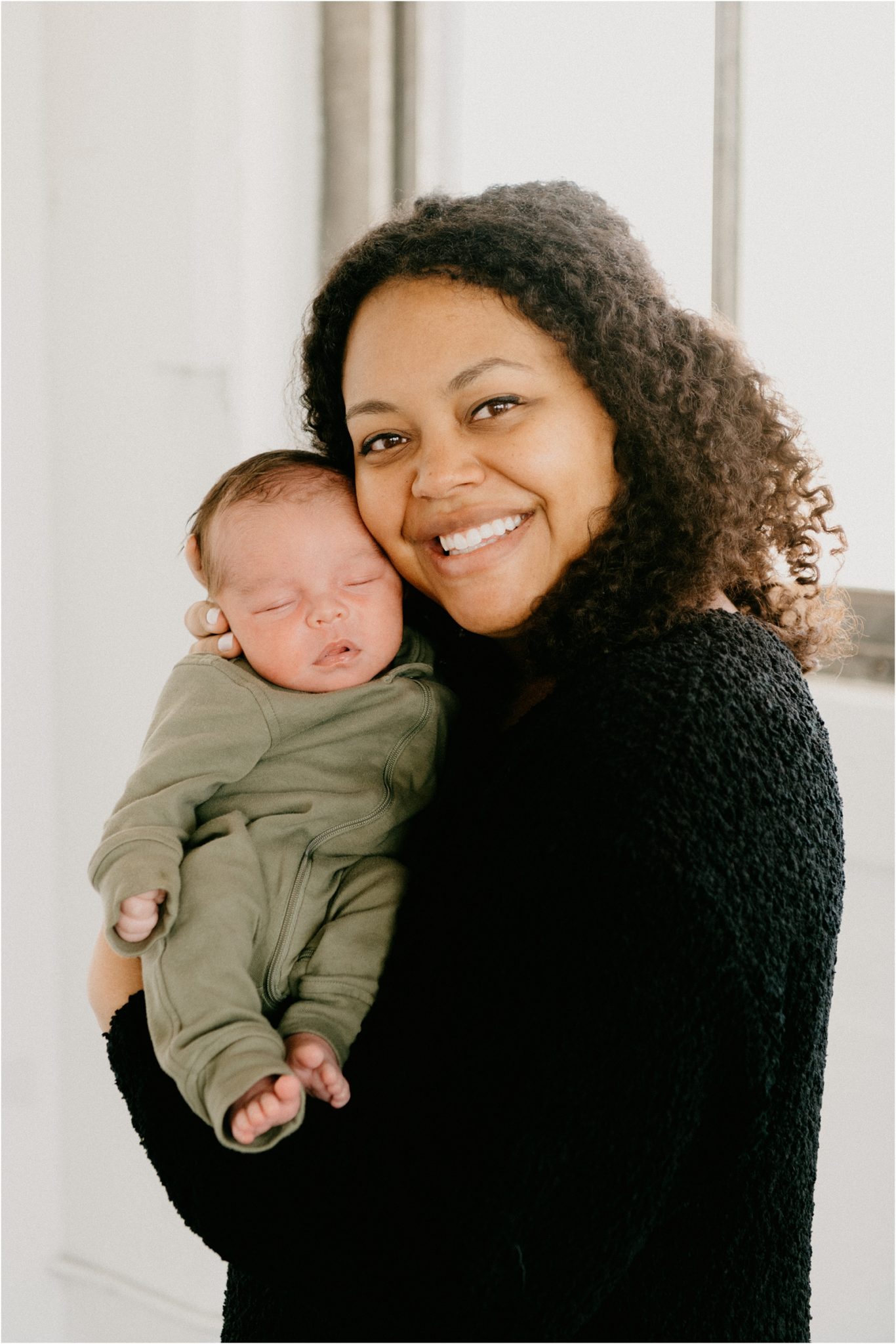 mom holding baby smiling at camera