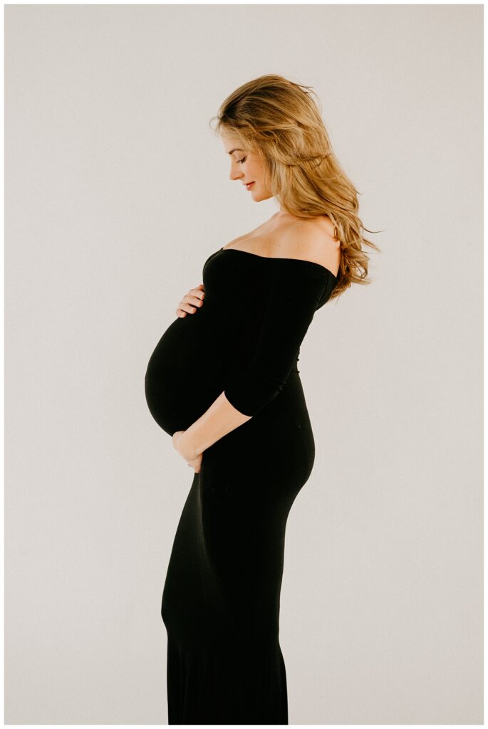 maternity session with a woman in a black dress