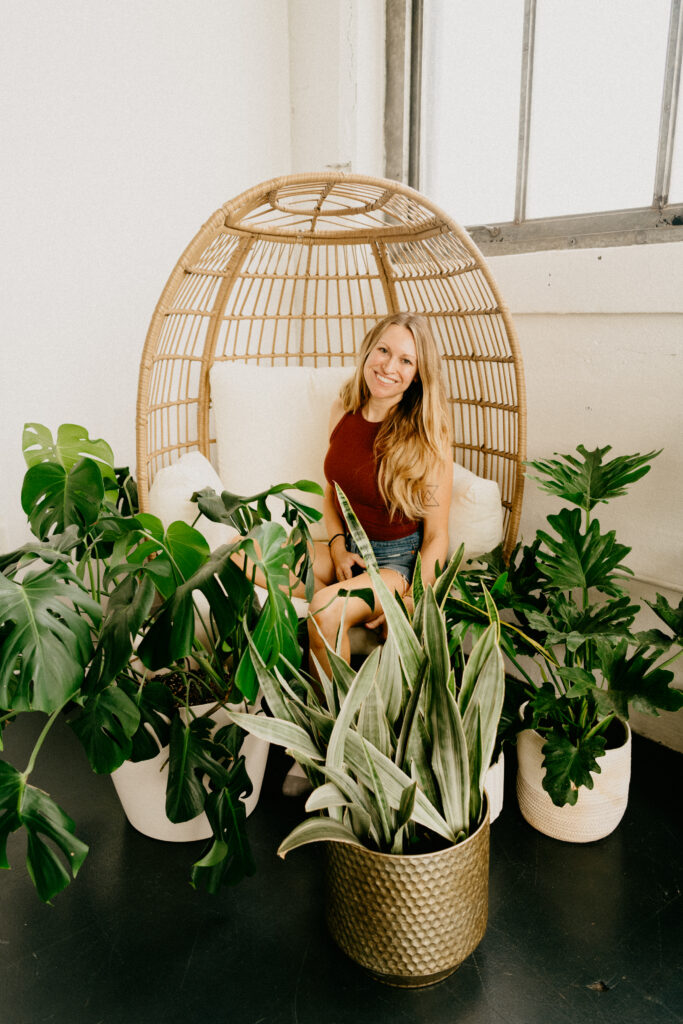 girl smiling sitting in chair with plants