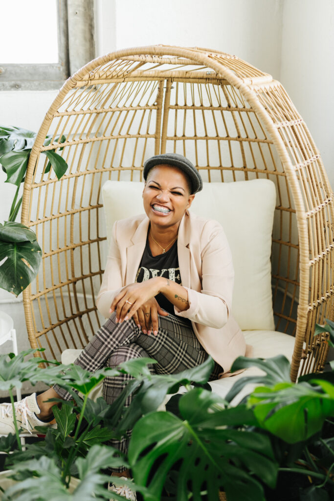 woman smiling in boho chair with plants