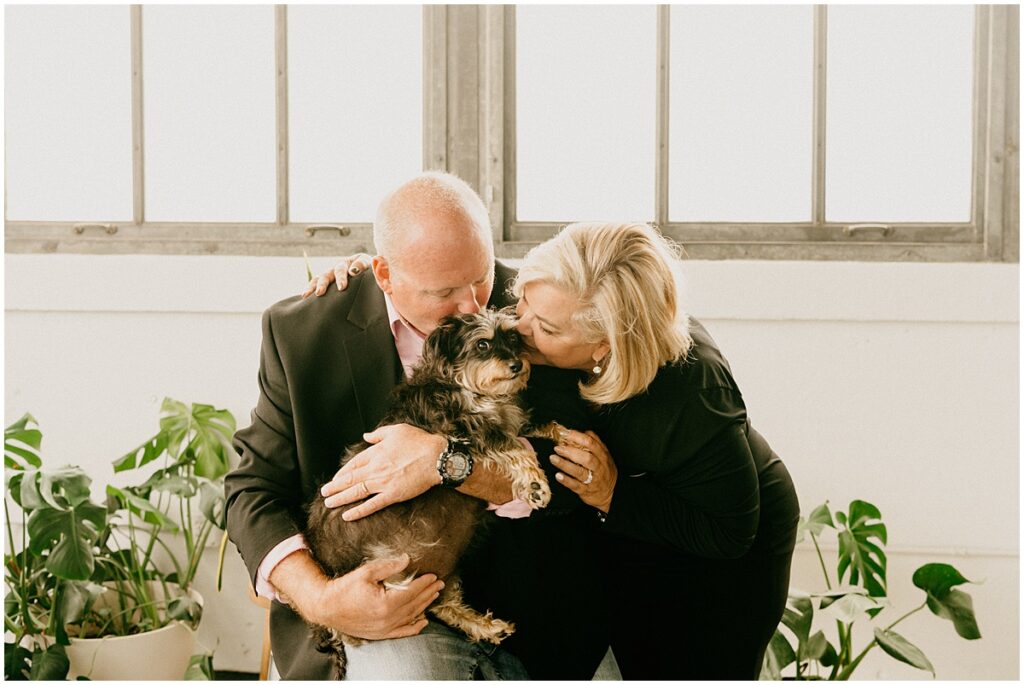 husband and wife kissing dog