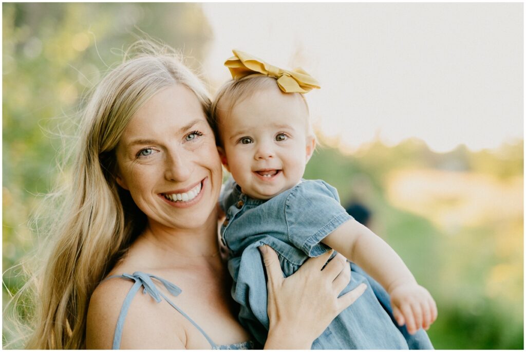 mom and baby with a bow smiling for camera