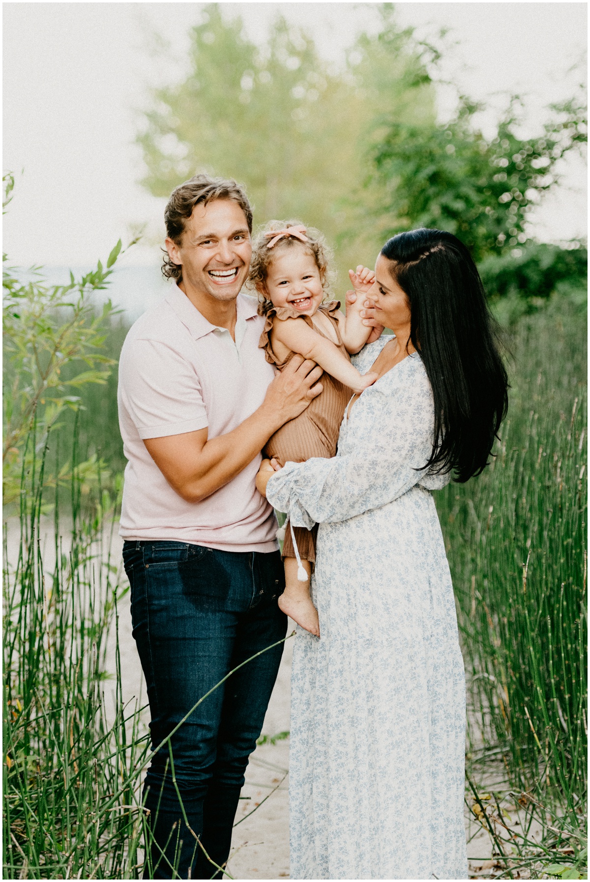 mom and dad and little girl smiling