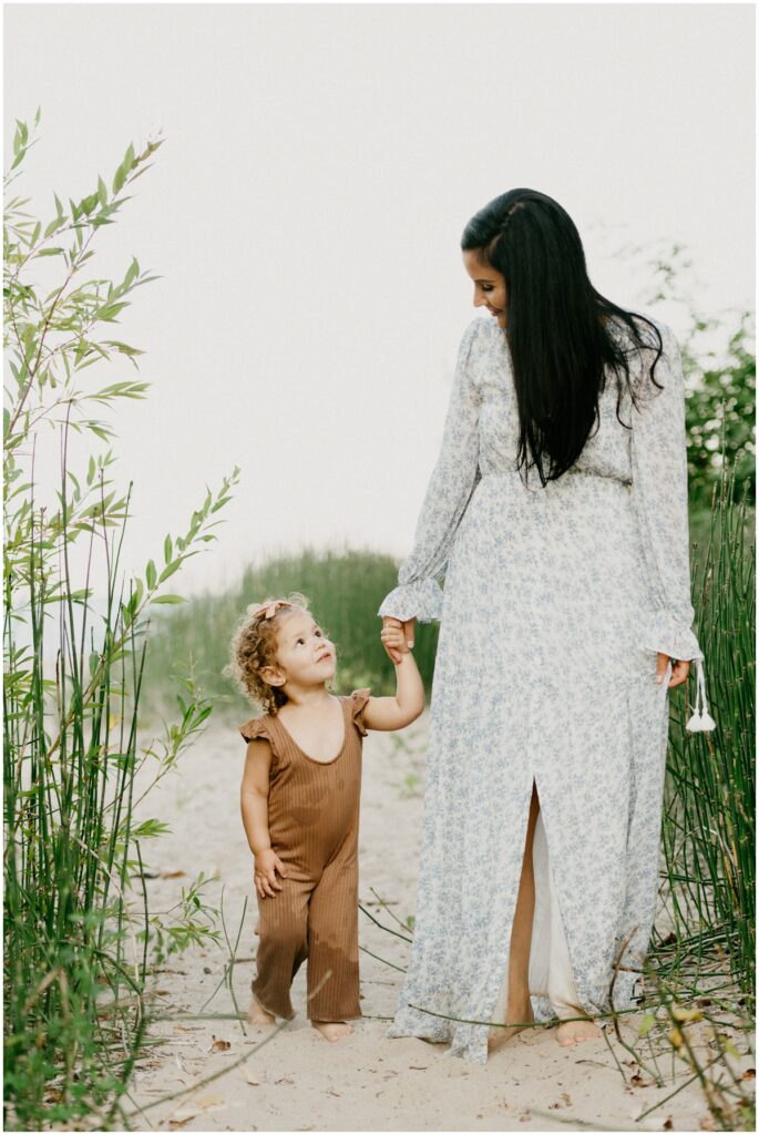 little girl walking with mom on beach