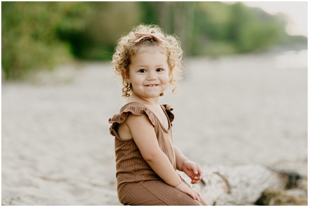 little girl sitting on a beach