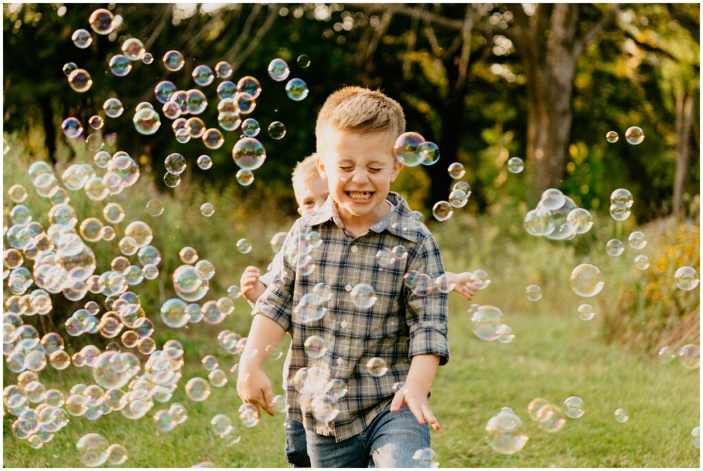 boy smiling running with bubbles
