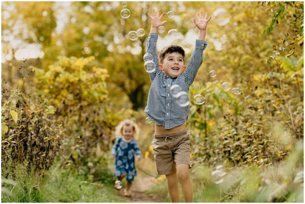 little boy jumping for bubbles