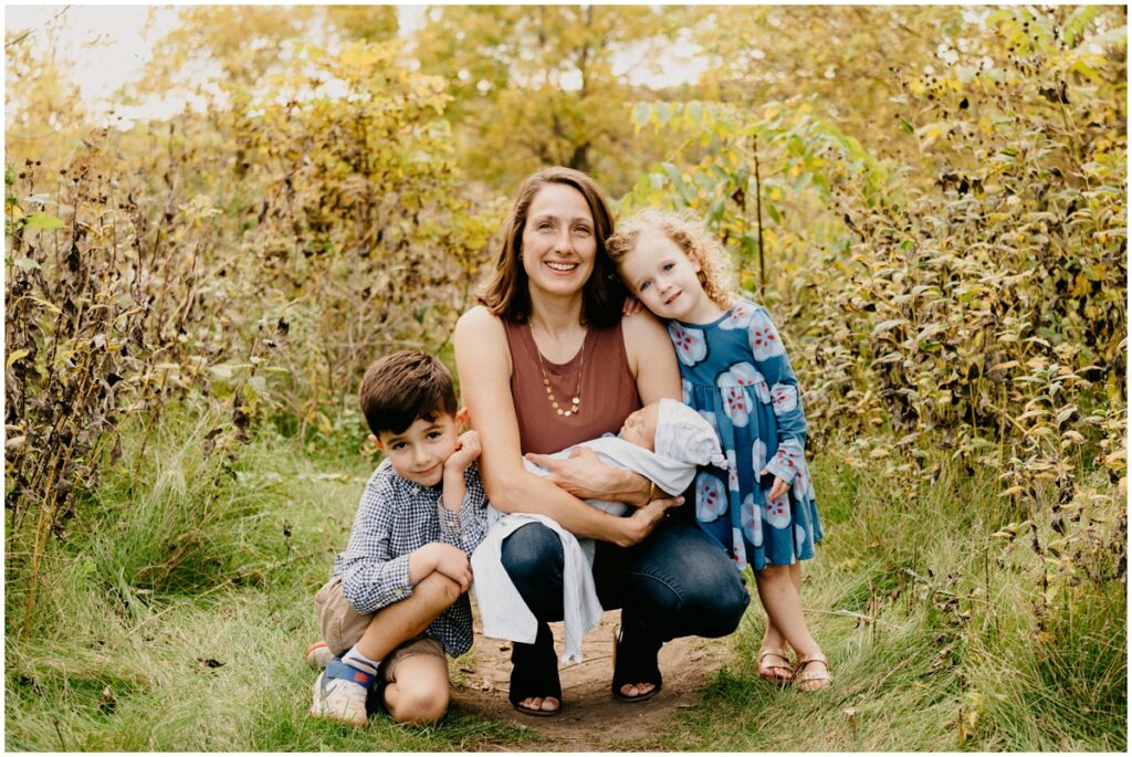 family smiling at a park in the fall