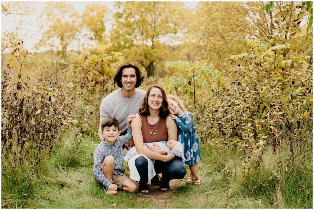family smiling at a park