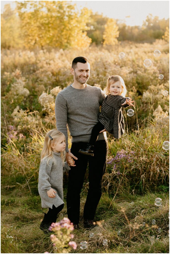 dad with two daughters at a park