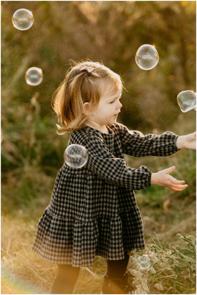 girl at park playing with bubbles