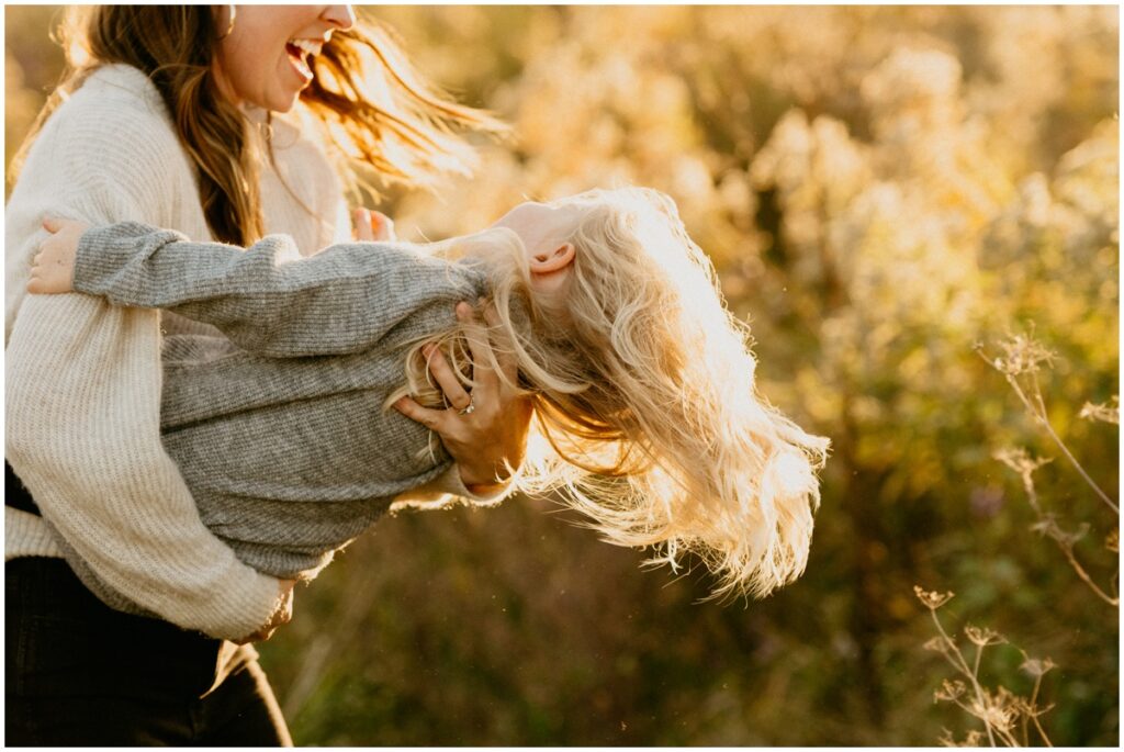mom dancing with daughter at Wisconsin park in the fall