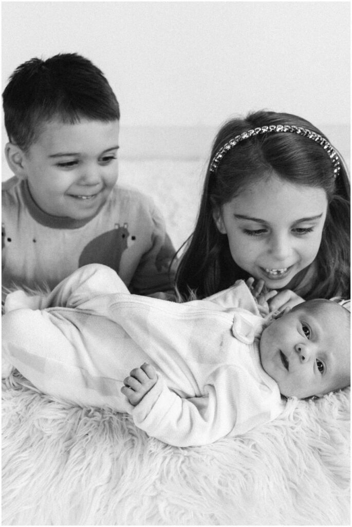 baby girl with smiling siblings
