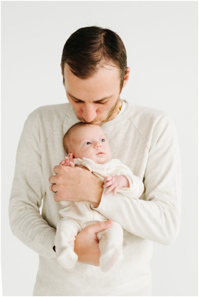 dad kissing newborn baby girl