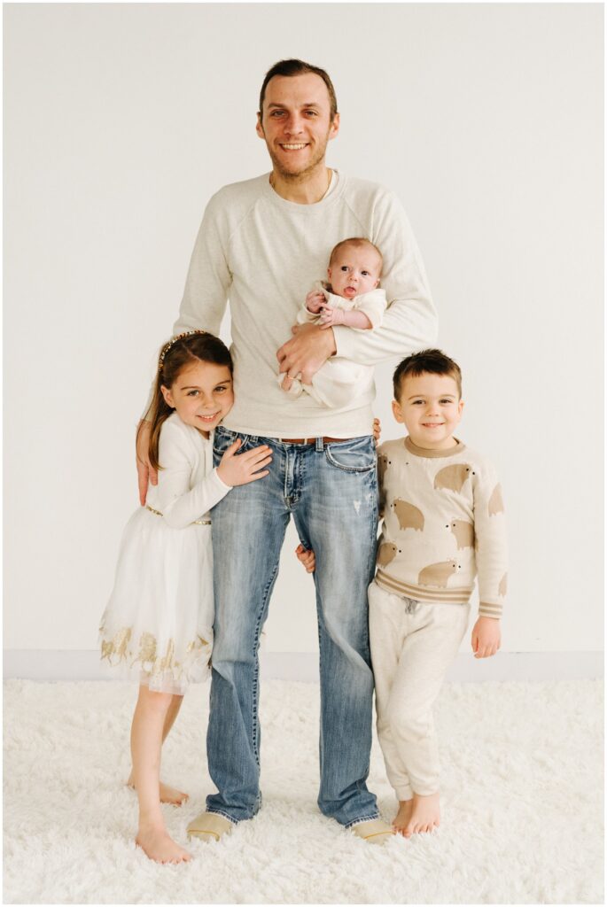 dad smiling with three kids