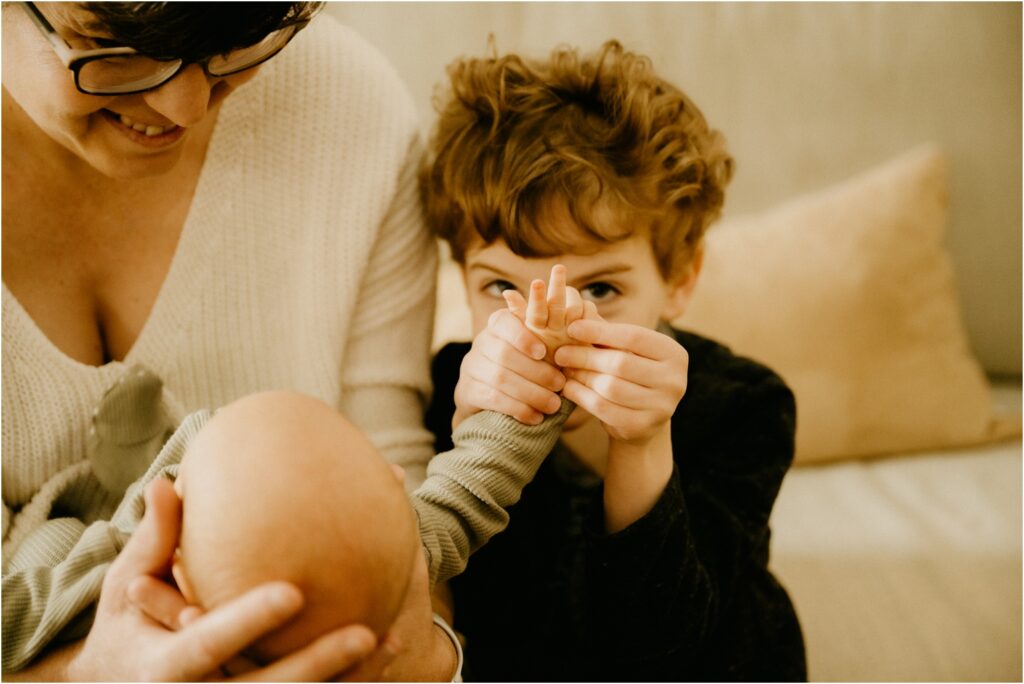 little boy holding baby sister hand