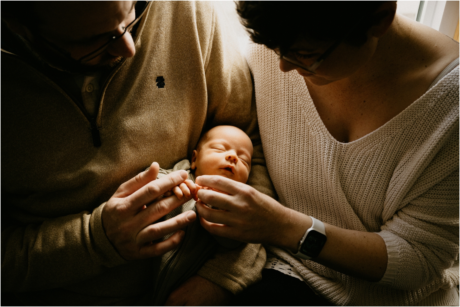 mom and dad holding baby infant