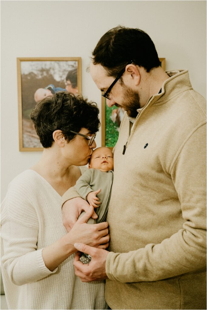 newborn being kissed by parents