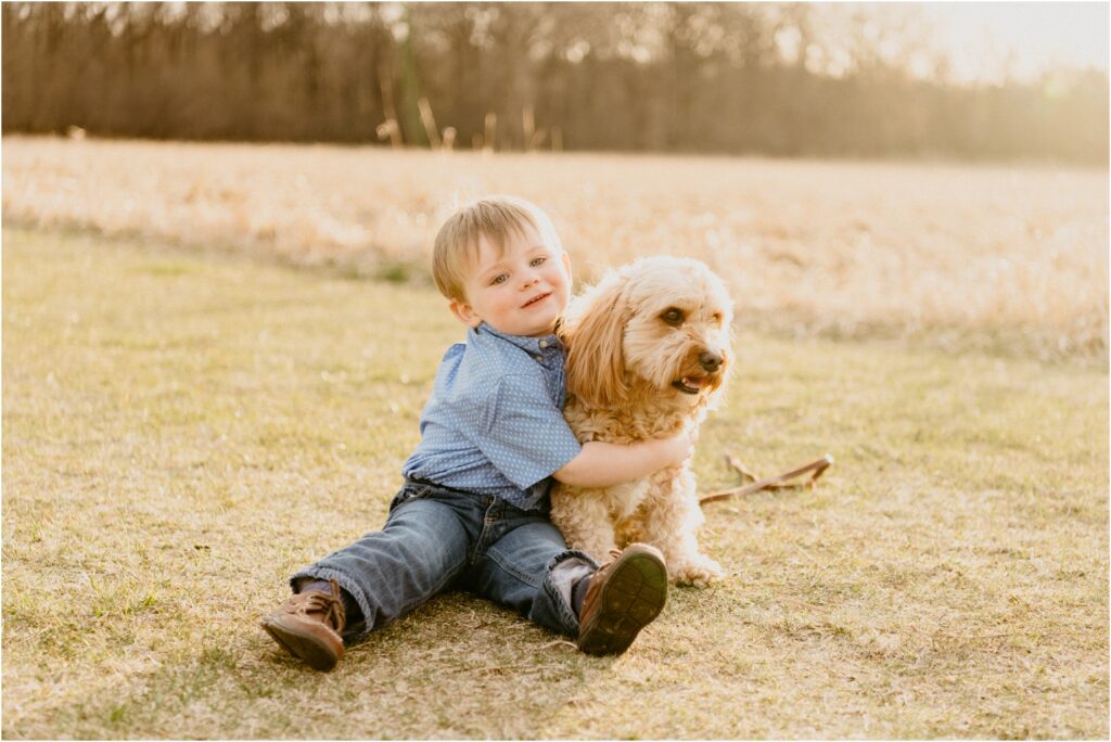 smiling boy in blue hugging pet dog