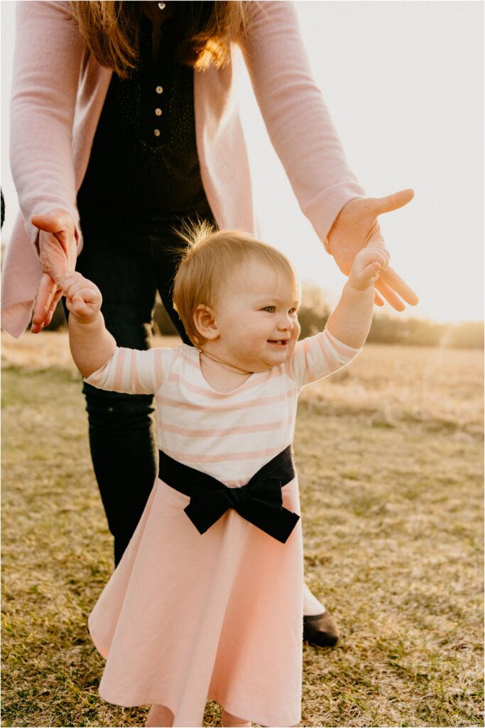 baby girl learning to walk smiling
