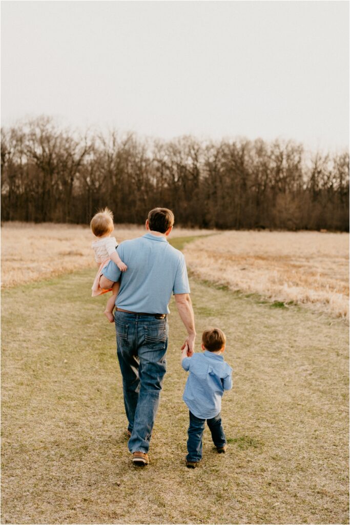 dad with kids walking away at park