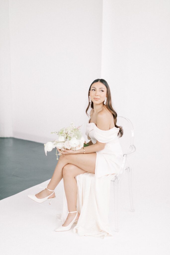 a bride holding flowers on white backdrop