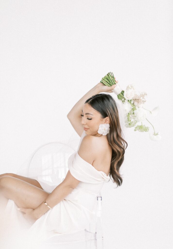 a bride holding flowers on white backdrop