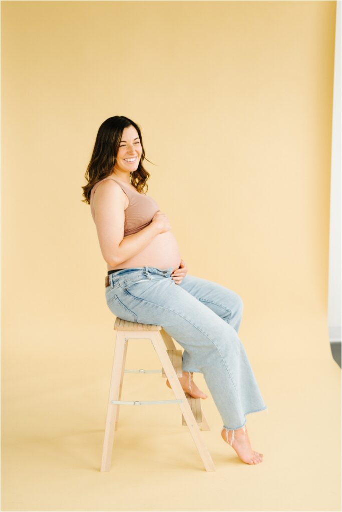 maternity photo of a woman on a beige backdrop