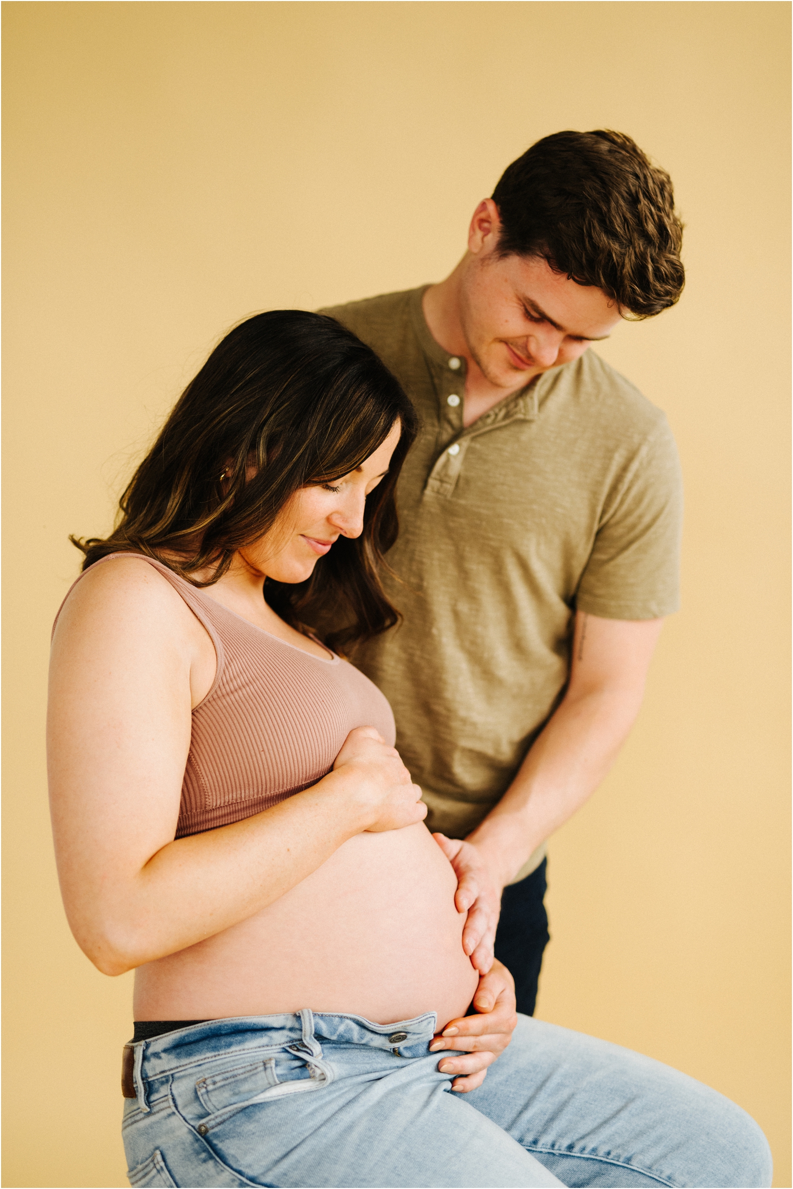 maternity photo of a woman on a beige backdrop