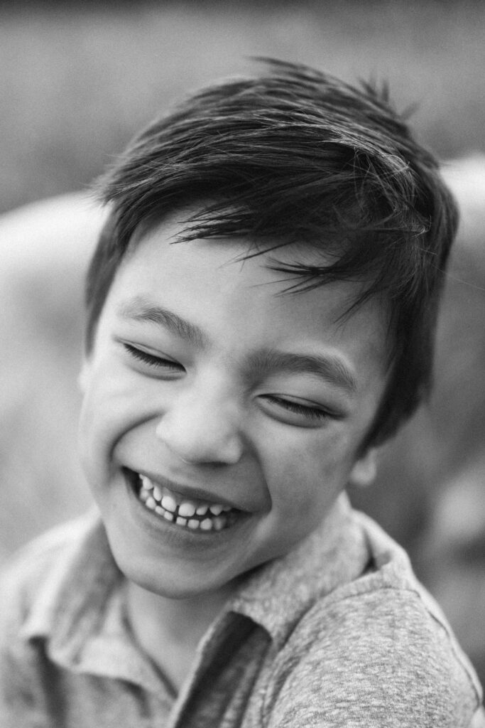 black and white photo of boy giggling