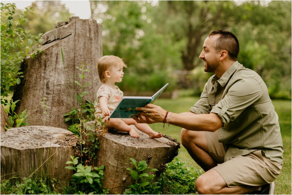 dad reading book to his daughter outside