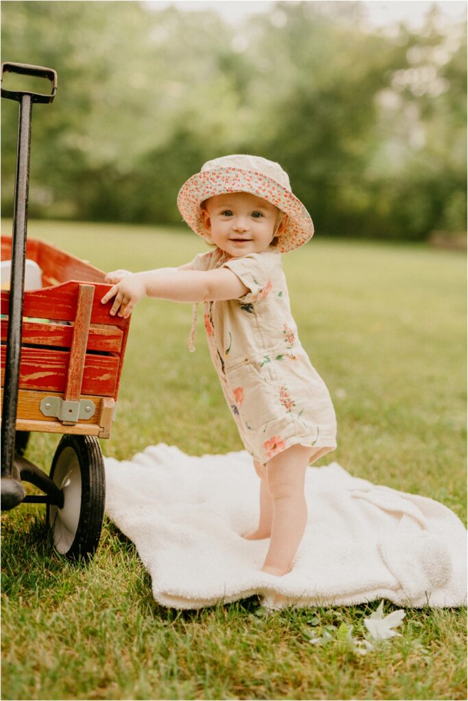 happy girl standing by red wagon