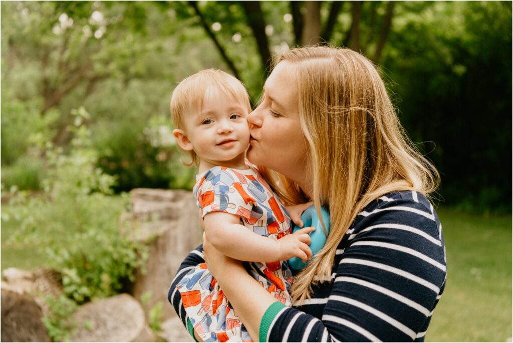 mom kissing the cheek of her daughter
