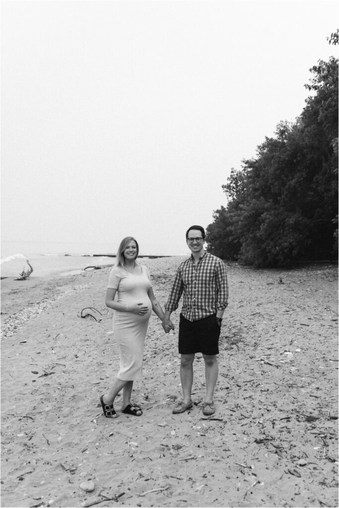 pregnant couple on the beach walking