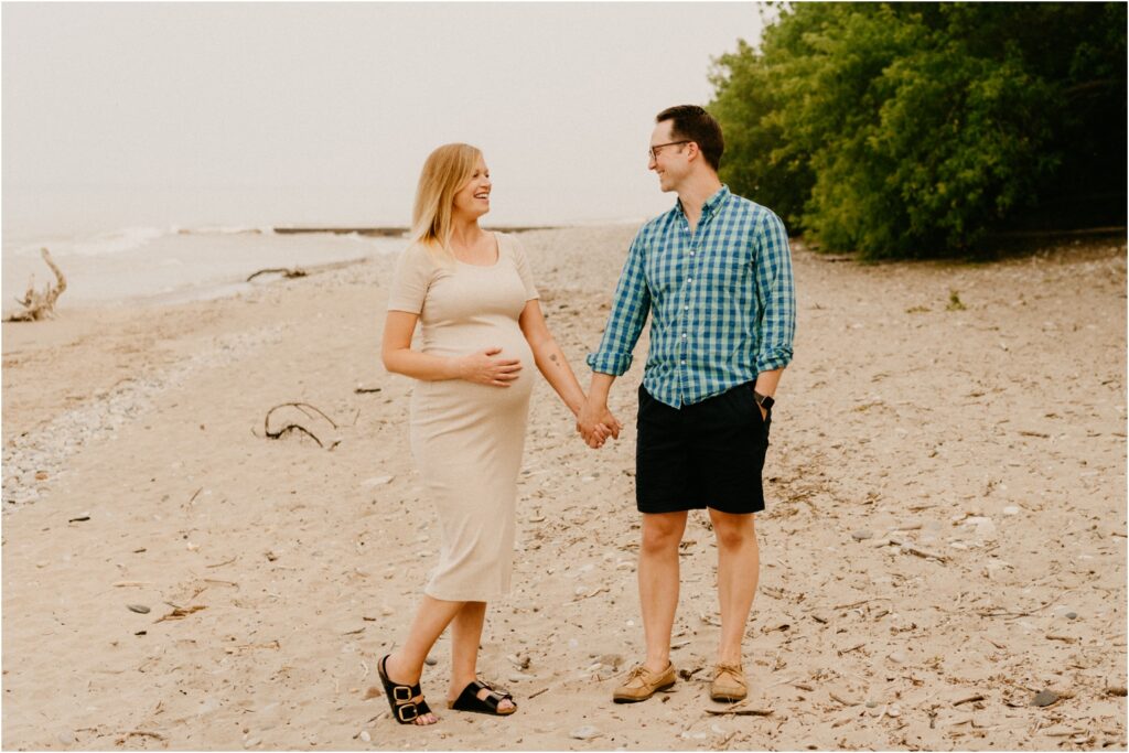 pregnant couple on the beach walking