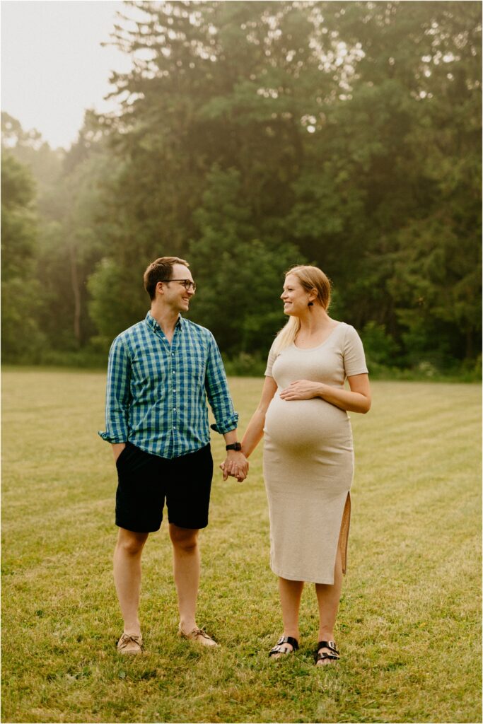 smiling pregnant couple holding hands