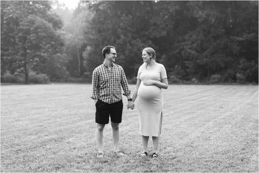 smiling pregnant couple holding hands