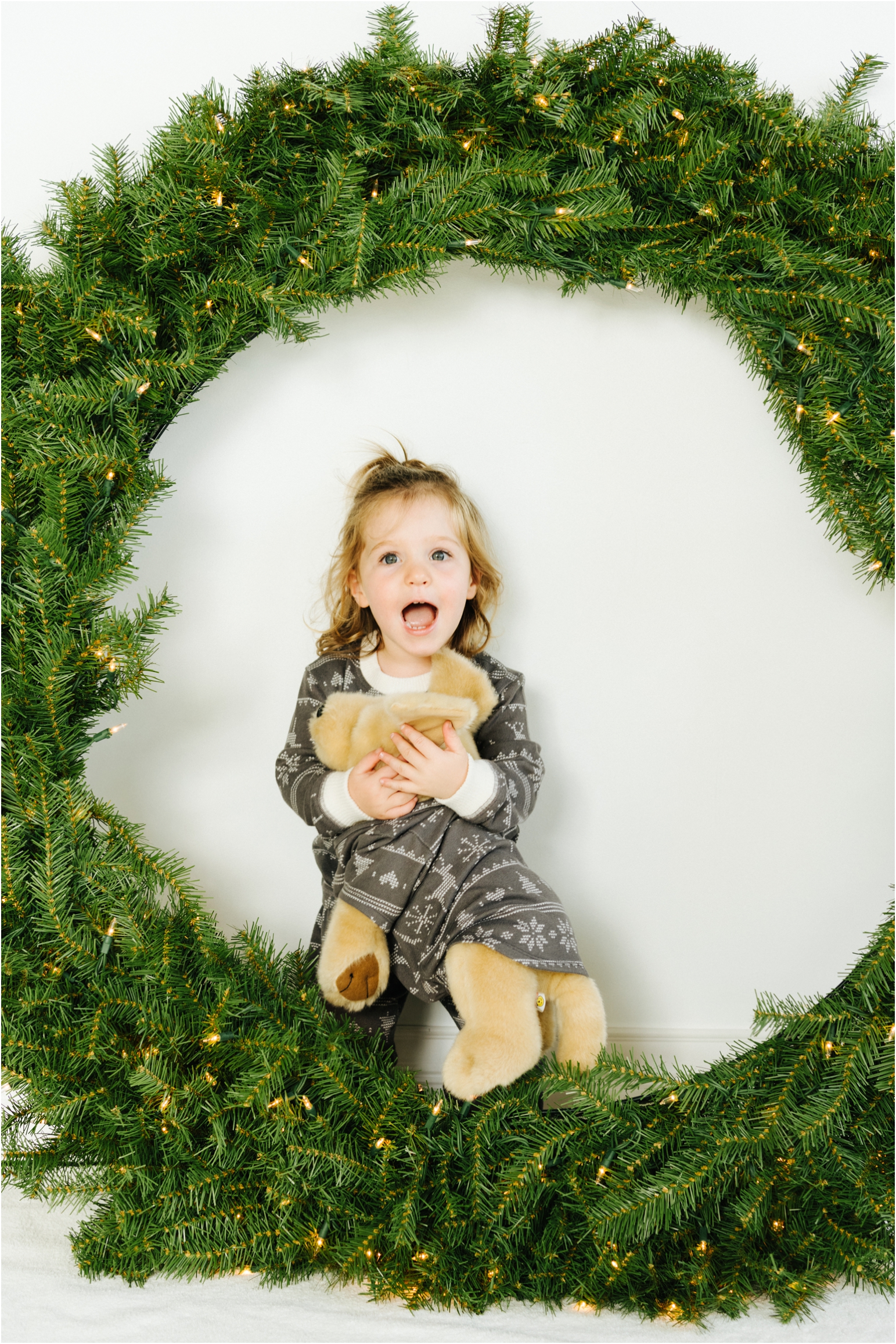 excited little girl near wreath with doggy