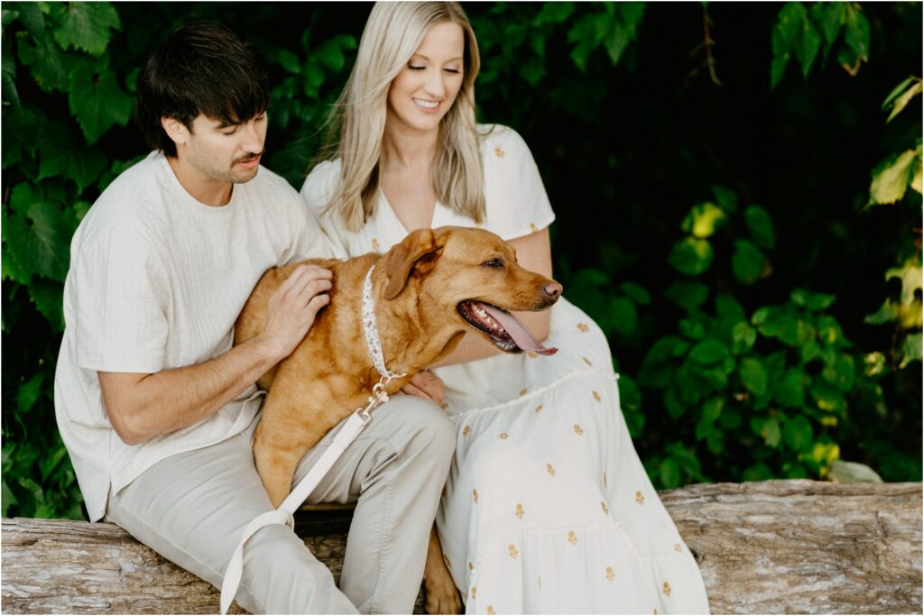 husband and wife petting their dog