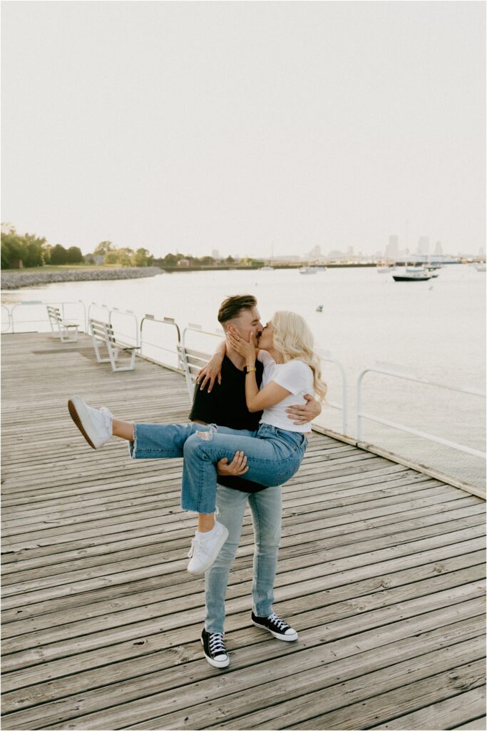 a couple kissing on the dock by the lake