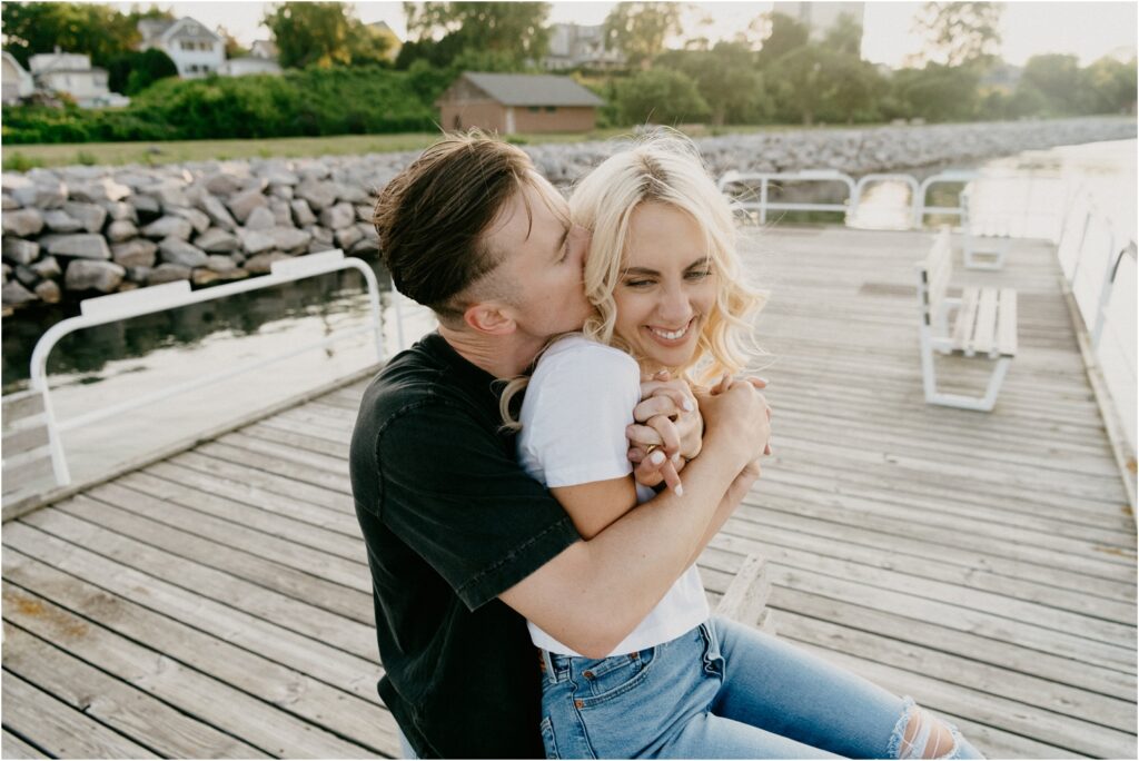 an engagement photo of a couple hugging and smiling