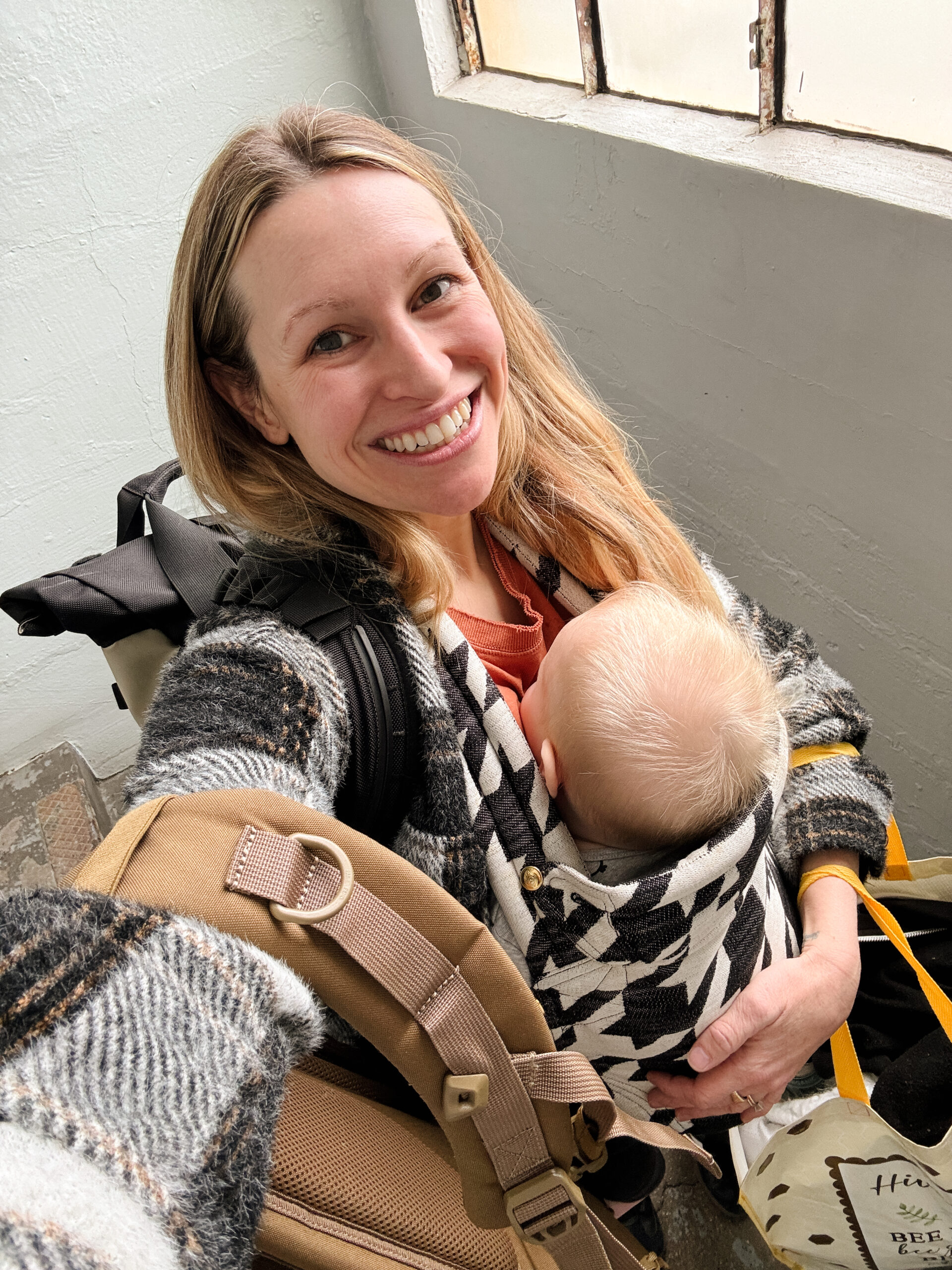 smiling woman with baby holding bags