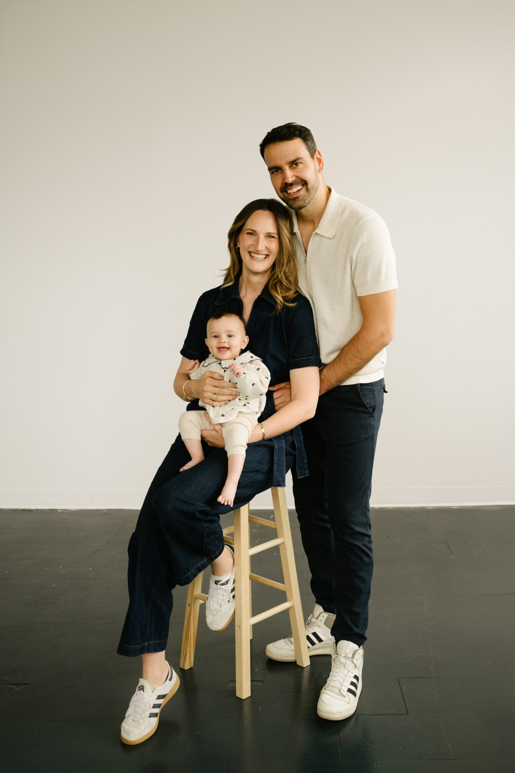 adorable family smiling with their daughter at a studio